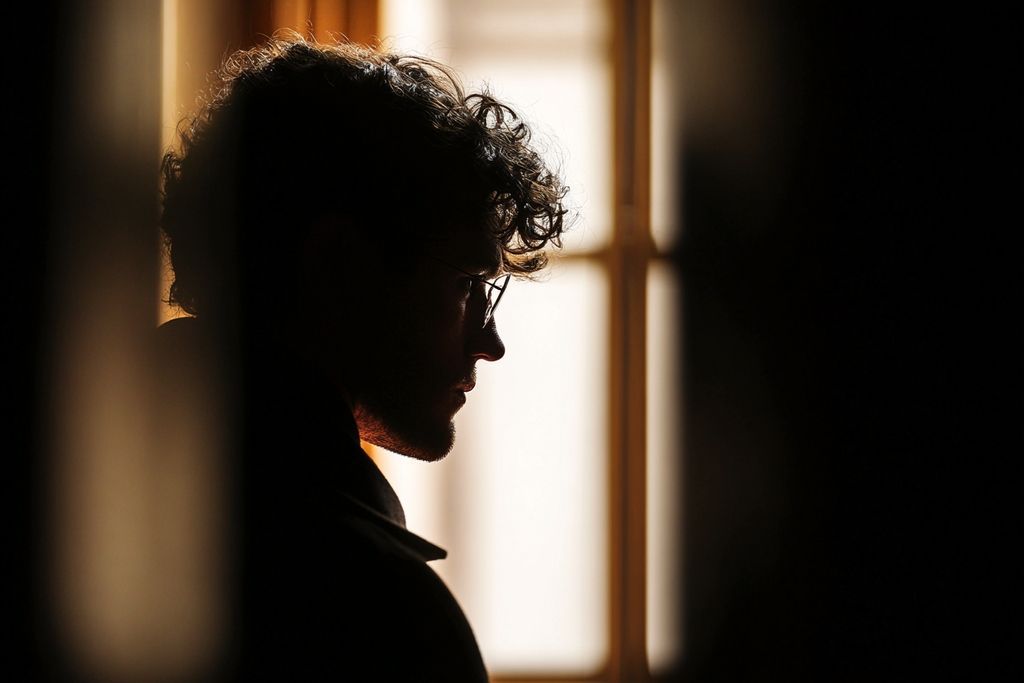 Silhouette contemplative regardant par la fenêtre d'un palais de justice
